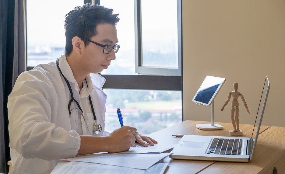 A Medical Doctor Taking Health Information from his Computer